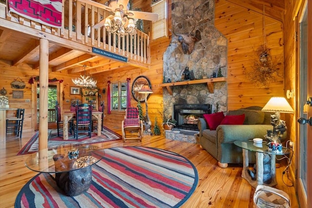 living room with a stone fireplace, wood ceiling, a wealth of natural light, and hardwood / wood-style floors