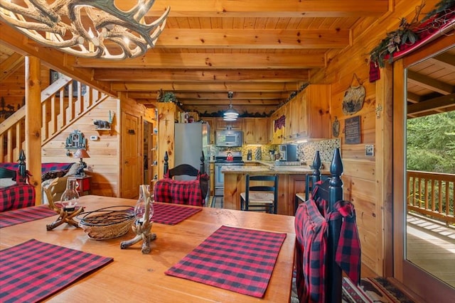 dining space featuring wooden ceiling, wood walls, hardwood / wood-style flooring, and beam ceiling