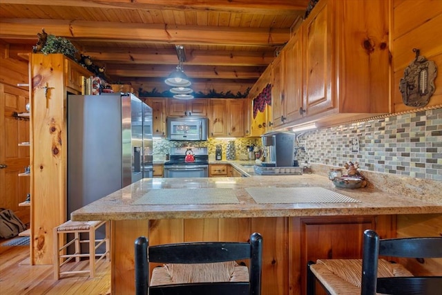 kitchen with stainless steel appliances, kitchen peninsula, a breakfast bar area, wood ceiling, and beam ceiling