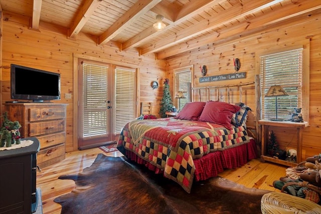 bedroom with wooden ceiling, wooden walls, and multiple windows