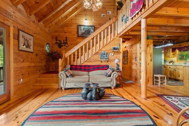 living room with beamed ceiling, hardwood / wood-style flooring, wood walls, high vaulted ceiling, and wood ceiling