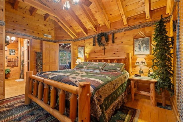 bedroom with wood ceiling, wood walls, wood-type flooring, and beamed ceiling