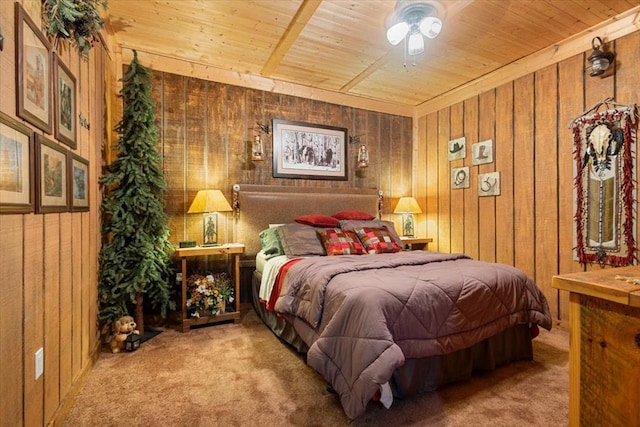 bedroom with wooden ceiling, carpet floors, ceiling fan, and wood walls