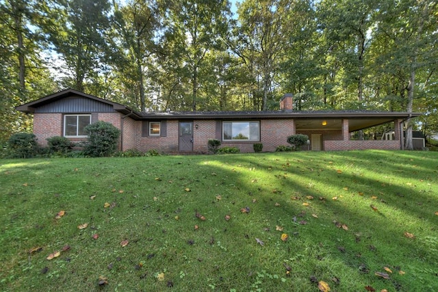 ranch-style home with brick siding, a chimney, and a front yard