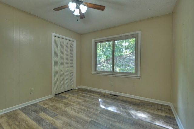 unfurnished room with light wood-style floors, visible vents, ceiling fan, and baseboards