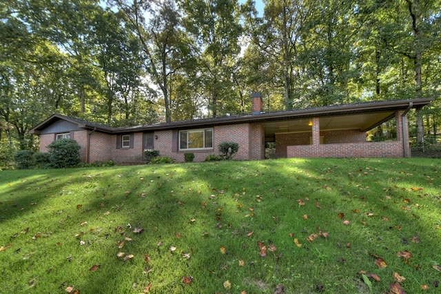 ranch-style home with a front yard, brick siding, and a chimney