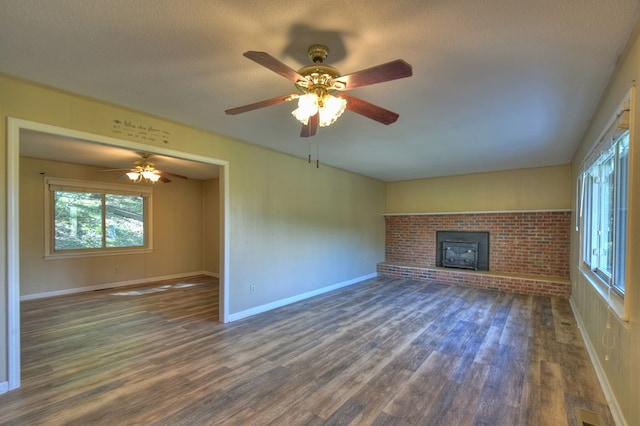 unfurnished living room with a textured ceiling, dark wood-style flooring, and baseboards