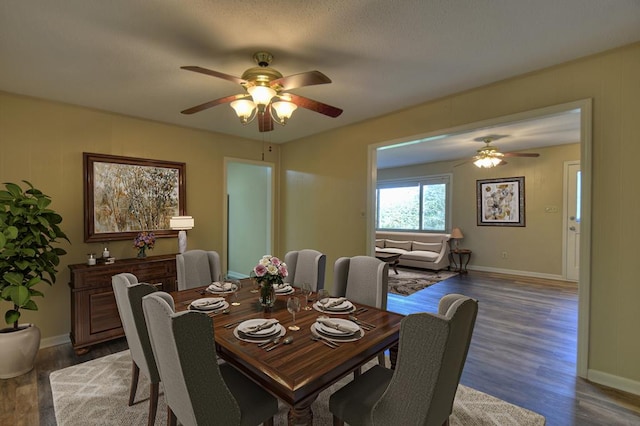 dining area featuring dark wood-type flooring, a ceiling fan, and baseboards