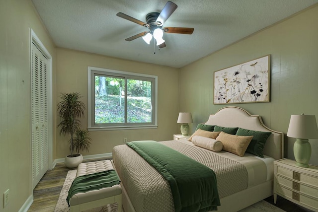 bedroom featuring a closet, ceiling fan, baseboards, and wood finished floors