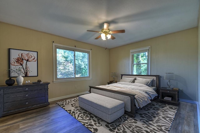 bedroom with dark wood-type flooring, ceiling fan, and baseboards