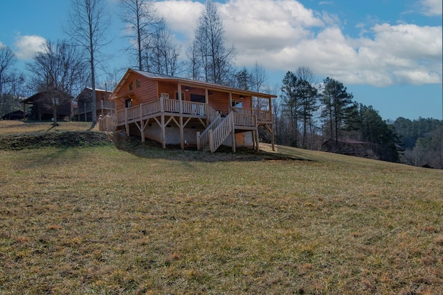 rear view of house with a wooden deck and a yard