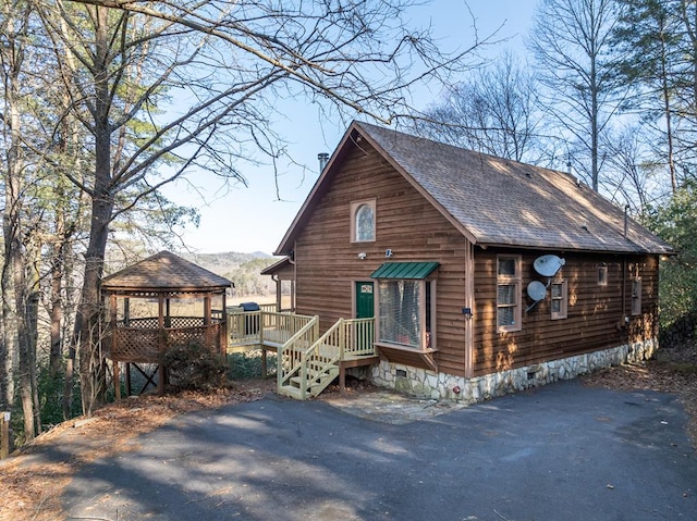 view of front of property featuring crawl space, a shingled roof, and a gazebo