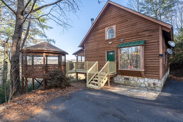 rustic home featuring a gazebo and a wooden deck