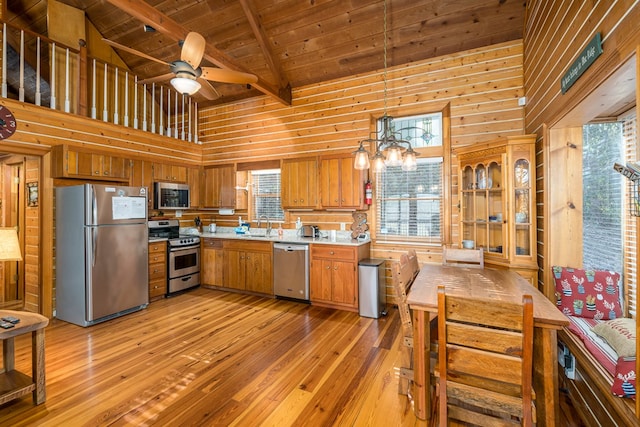 kitchen featuring sink, wood ceiling, decorative light fixtures, appliances with stainless steel finishes, and beamed ceiling