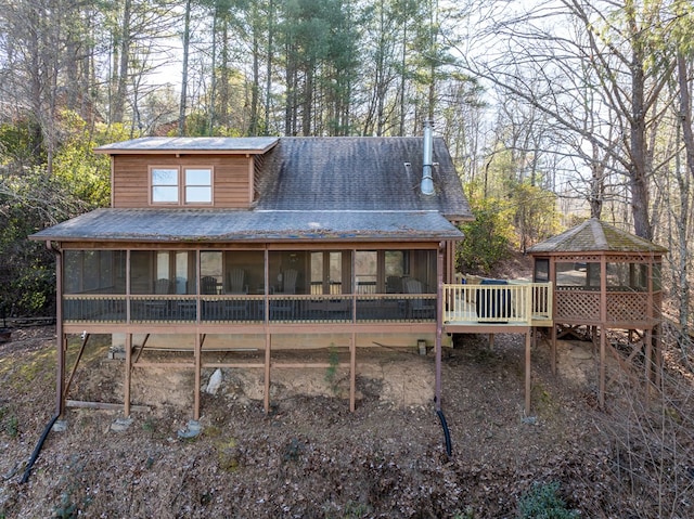 back of property featuring a gazebo and a sunroom