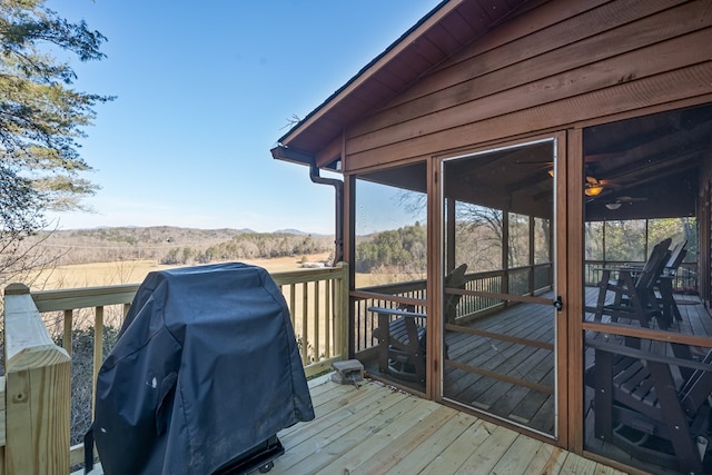 wooden terrace featuring a grill and a sunroom