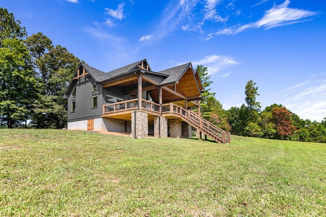 rear view of property featuring a lawn and a deck