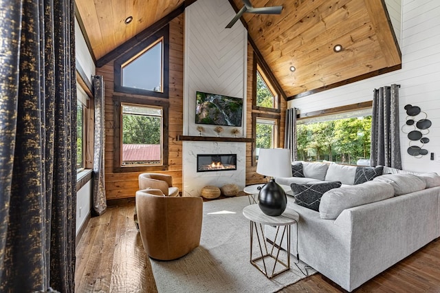 living room featuring wood walls, hardwood / wood-style flooring, and high vaulted ceiling