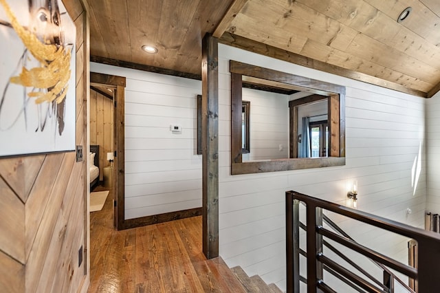 corridor with wooden walls, hardwood / wood-style floors, and wood ceiling