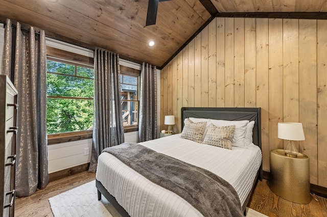 bedroom with wooden ceiling, light hardwood / wood-style floors, wooden walls, and vaulted ceiling