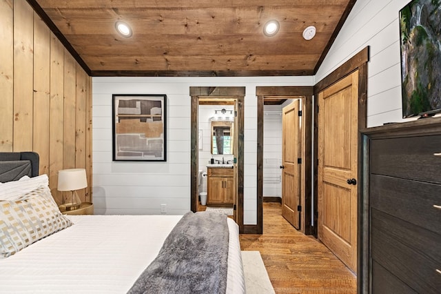 bedroom featuring wooden ceiling, ensuite bath, light hardwood / wood-style flooring, and lofted ceiling