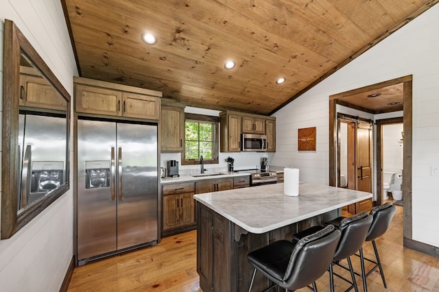 kitchen with appliances with stainless steel finishes, light hardwood / wood-style floors, vaulted ceiling, and wooden ceiling