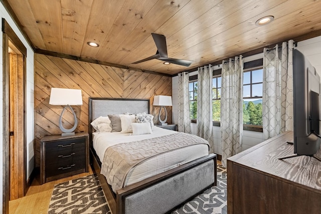 bedroom with wooden ceiling, light hardwood / wood-style floors, ceiling fan, lofted ceiling, and wooden walls