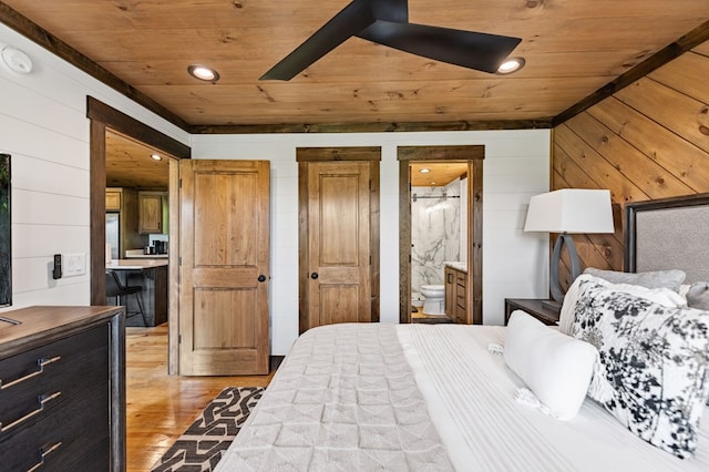 bedroom with light hardwood / wood-style floors, ensuite bath, wooden walls, and wood ceiling