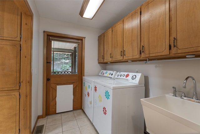 laundry room with light tile patterned floors, a sink, visible vents, cabinet space, and washing machine and clothes dryer