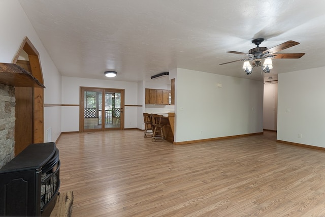 living area featuring baseboards, visible vents, light wood-style flooring, and a textured ceiling