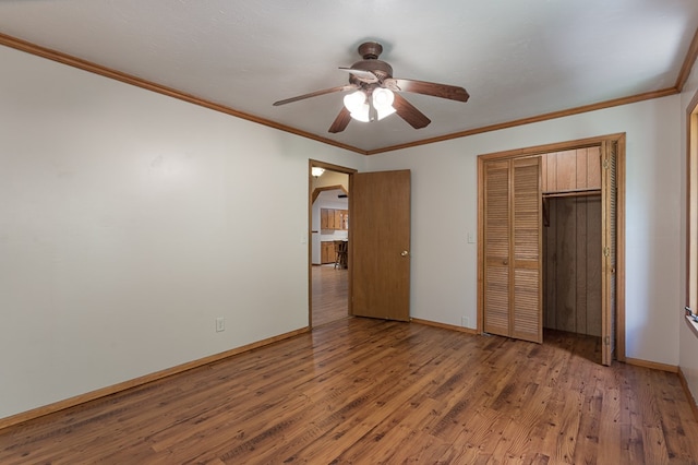 unfurnished bedroom with baseboards, wood finished floors, and crown molding