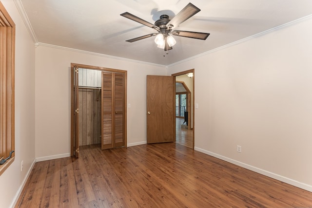 unfurnished bedroom with ceiling fan, wood finished floors, baseboards, ornamental molding, and a closet