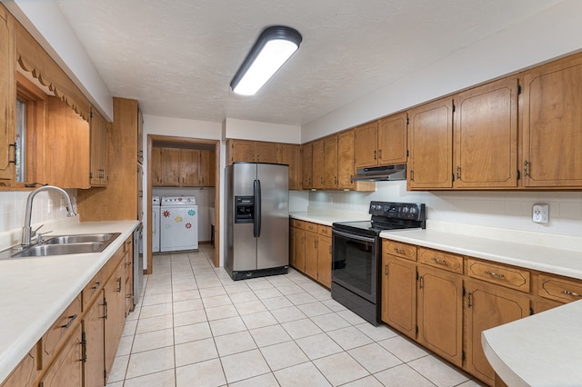 kitchen featuring under cabinet range hood, stainless steel appliances, a sink, light countertops, and brown cabinets