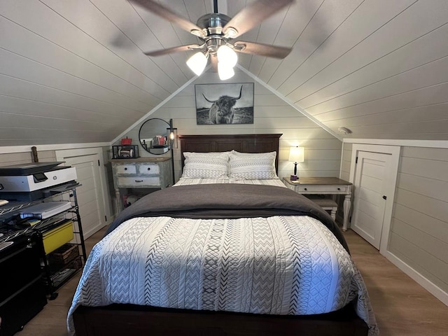 bedroom featuring wooden ceiling, vaulted ceiling, wood finished floors, and wood walls