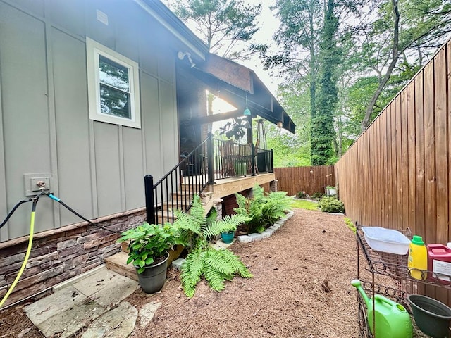 view of side of property featuring board and batten siding and a fenced backyard