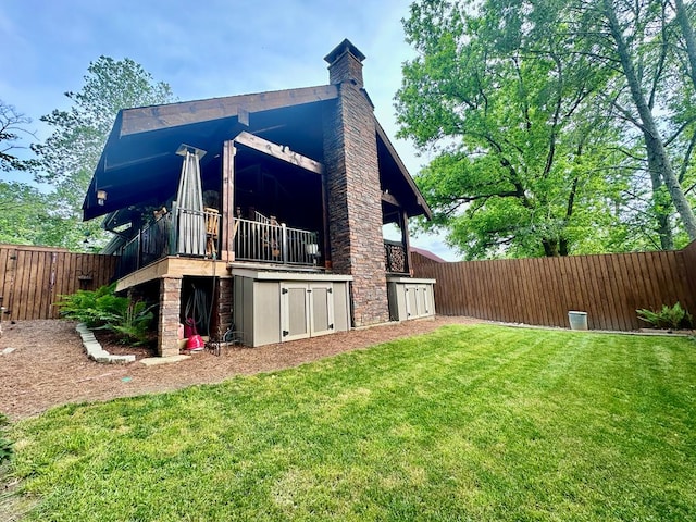 view of side of home with stone siding, a lawn, a chimney, and a fenced backyard