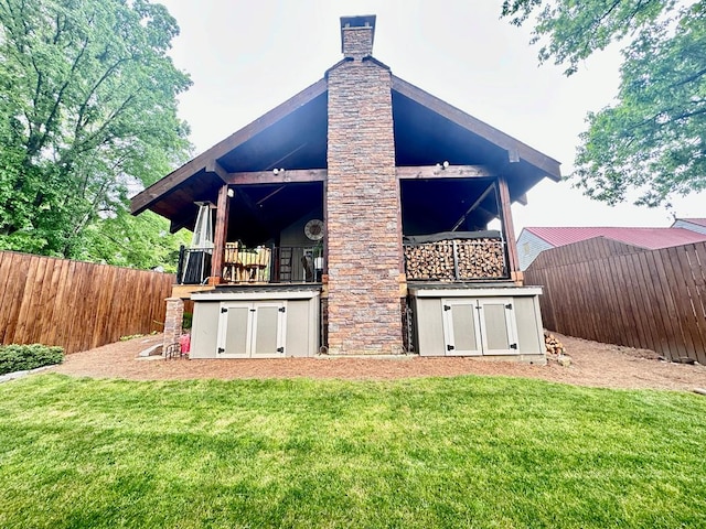 back of house with a yard, a chimney, and fence