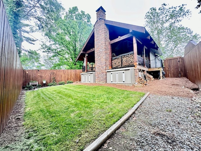 view of property exterior with stone siding, a fenced backyard, a yard, and a chimney