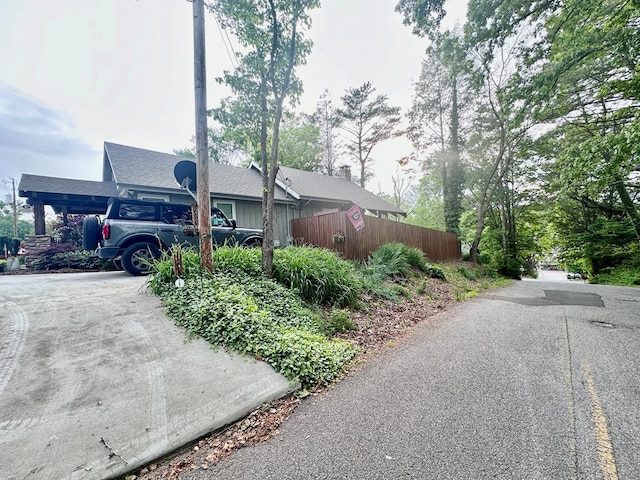 view of home's exterior featuring driveway and fence