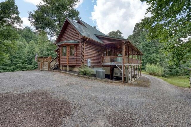 1394 Camp Creek Rd, Murphy, NC 28906 - view of home's exterior with log exterior, gravel driveway, a deck, and metal roof