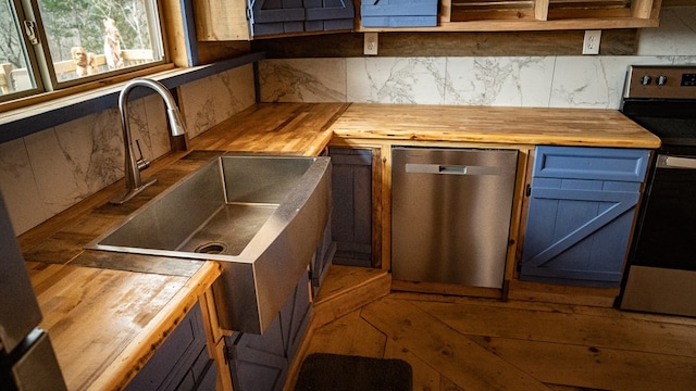 kitchen with stainless steel appliances, wooden counters, and backsplash