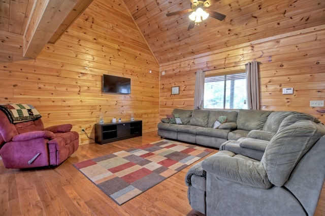 living area with wooden walls, ceiling fan, wooden ceiling, wood finished floors, and high vaulted ceiling