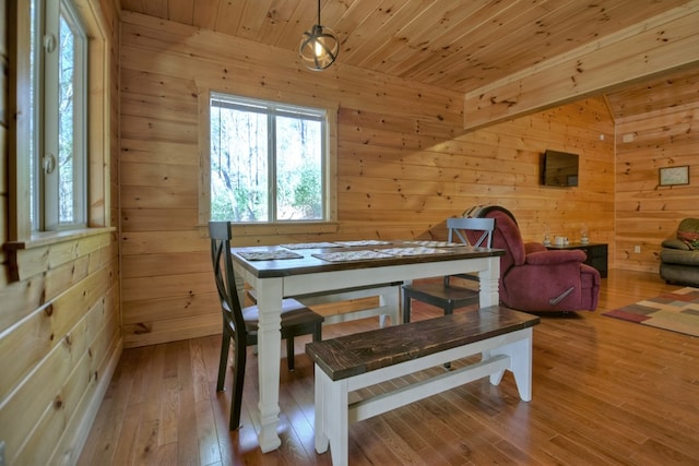 dining area with wooden ceiling, wooden walls, and wood-type flooring