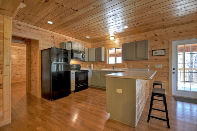 kitchen featuring wood ceiling, gray cabinets, black appliances, and a breakfast bar