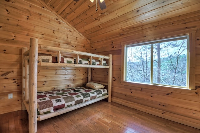 bedroom with lofted ceiling, wooden walls, wood ceiling, and wood-type flooring