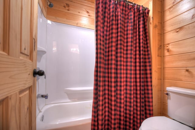 bathroom with toilet, wooden walls, and shower / bath combination with curtain