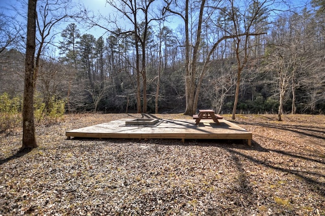 view of yard featuring a view of trees and a deck