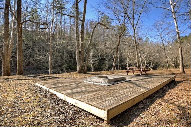 view of property's community with a wooden deck and a view of trees