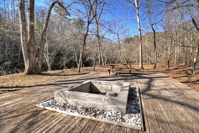 deck featuring a fire pit and a view of trees