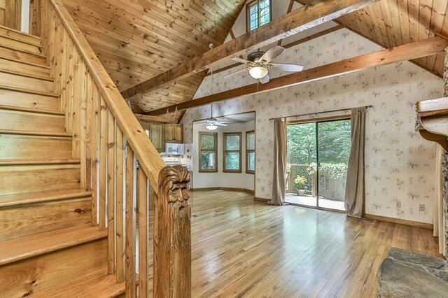 stairs featuring ceiling fan, beamed ceiling, light hardwood / wood-style flooring, and wooden ceiling